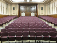 Back of room view of student auditorium seating and double exit doors at rear of room.