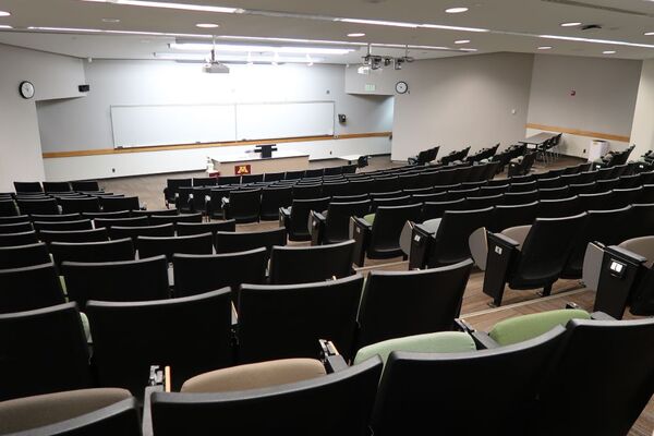 Front of room view with lectern center in front of markerboard and exit to right front 