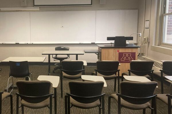 Front of room view with lectern on right side and projection screen partially lowered