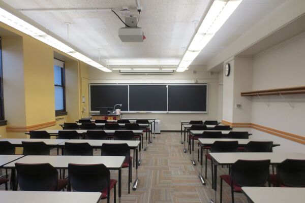 Front of room view with lectern on left side and projection screen partially lowered