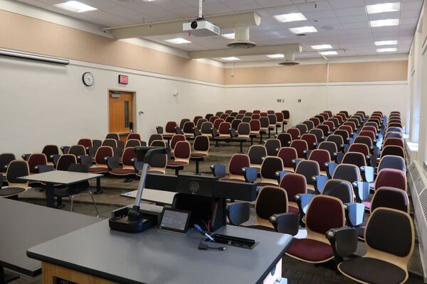 Back of room view of student auditorium seating and and exit door at left side of room