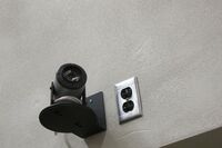 Camera mounted to a wall and instructor enabled adjustments to the lens to allow the instructor to be "seen" by the camera in more locations around the room