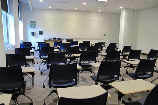 Front of room view with lectern on left side and projection screen fully raised