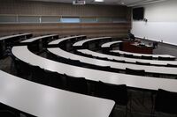 Front of room view with lectern center in front of markerboard and display screen to the left