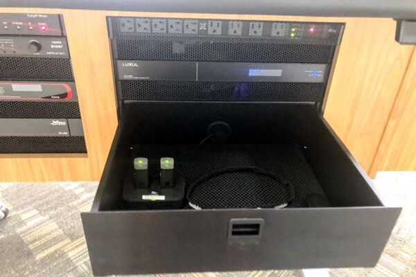 Pedestal - inside view of drawer showing two wireless mics in charging base