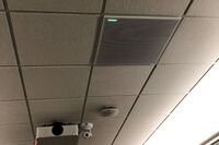 White 2¿ x 2¿ tile mounted in the ceiling to provide microphone coverage over student seating