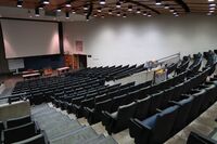 Front of room view with lectern center in front and projection screen lowered