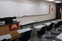 Front of room view with lectern on left in front of markerboard 