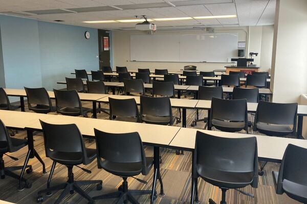  Front of room view with lectern on right in front of markerboard and exit door on the left