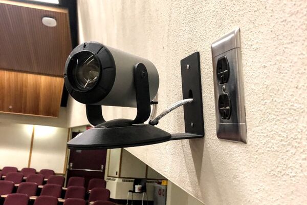 Camera mounted to a wall and instructor enabled adjustments to the lens to allow the instructor to be "seen" by the camera in more locations around the room