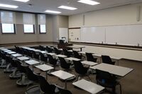 Front of room view with lectern on left in front of markerboard 