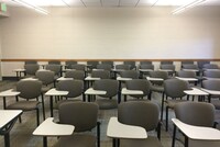 Back of room view of student tablet arm seating and exit door at left rear of room