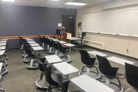 Front of room view with lectern on left in front of markerboard 