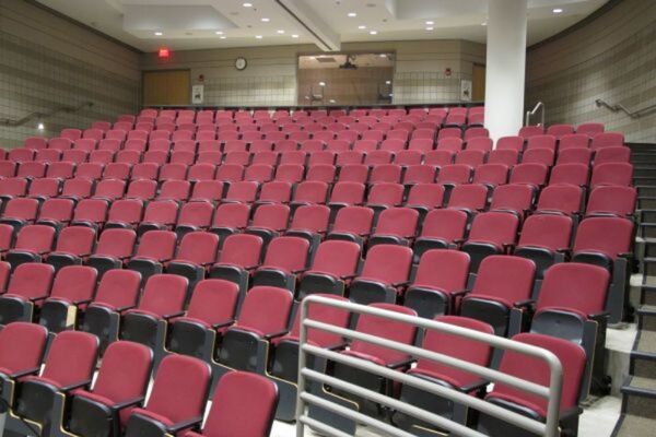 Back of room view of student auditorium seating and double exit doors at rear of room