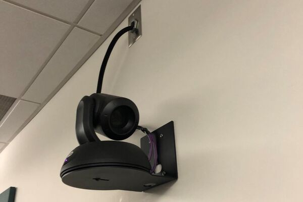 Camera mounted to a wall and instructor enabled adjustments to the lens to allow the instructor to be "seen" by the camera in more locations around the room