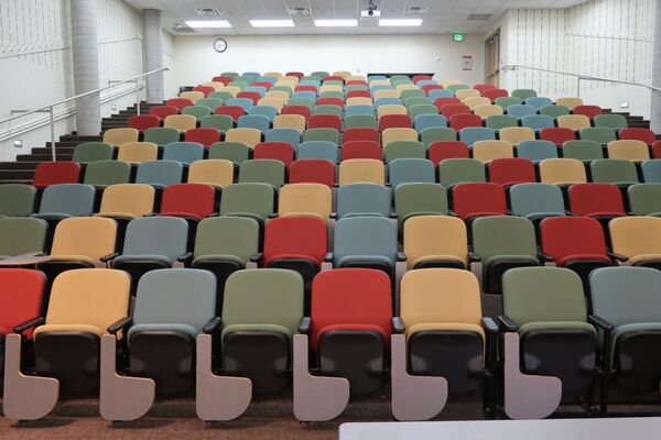 Back of room view of student auditorium seating and double exit doors at right rear of room