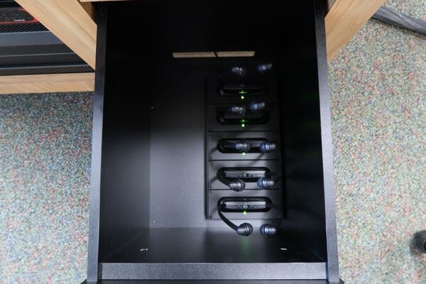 Pedestal - inside view of drawer showing assistive listening devices in charging base