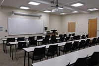 Front of room view with lectern on right in front of markerboard 