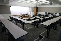 Front of room view with lectern center in front of markerboard and exit door on the right