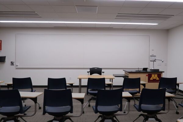 Front of room view with lectern on right side and projection screen fully raised