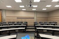 Back of room view of student tiered fixed-table and chair seating 