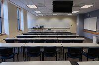 Front of room view with lectern on left in front of markerboard 