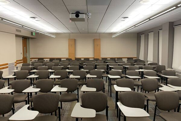 Back of room view of student tablet arm seating and double exit door at left rear of room