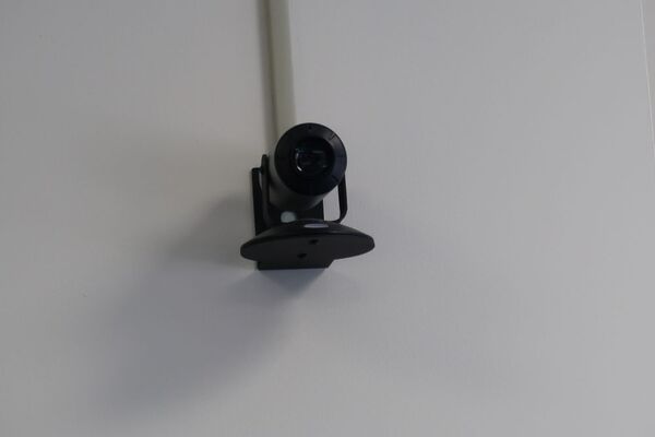 Camera mounted to a wall and instructor enabled adjustments to the lens to allow the instructor to be "seen" by the camera in more locations around the room