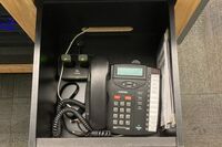 Pedestal - inside view of drawer showing two wireless mics in charging base and telephone