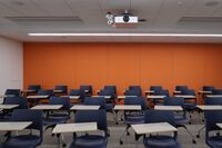 Rear of room view of student tablet arm chair seating on casters