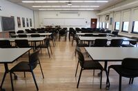 Front of room view with lectern on left in front of markerboard and movable chalkboard and markerboard on the left