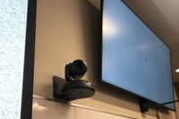 Camera mounted to a wall and instructor enabled adjustments to the lens to allow the instructor to be "seen" by the camera in more locations around the room