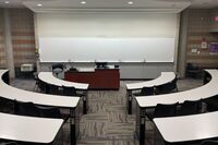 Front of room view with lectern center in front of markerboard, exit door on front right