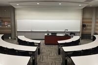 Front of room view with lectern on center in front of markerboard