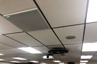 White 2¿ x 2¿ tile mounted in the ceiling to provide microphone coverage over student seating