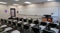 Front of room view with lectern on right in front of markerboard 