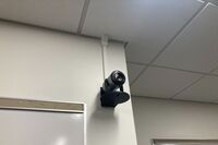 Camera mounted to a wall and instructor enabled adjustments to the lens to allow the instructor to be "seen" by the camera in more locations around the room