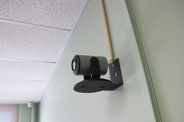 Camera mounted to a wall and instructor enabled adjustments to the lens to allow the instructor to be "seen" by the camera in more locations around the room