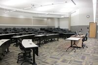 Back of room view of student tiered fixed-table and chair seating 