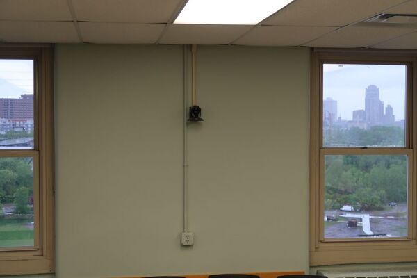 Camera mounted to a wall and instructor enabled adjustments to the lens to allow the instructor to be "seen" by the camera in more locations around the room