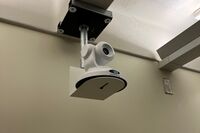 Camera mounted to a wall and instructor enabled adjustments to the lens to allow the instructor to be "seen" by the camera in more locations around the room