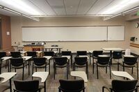 Front of room view with lectern on left in front of markerboard