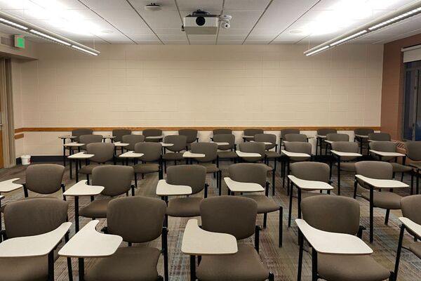 Back of room view of student tablet arm seating and exit door in left rear corner of the room