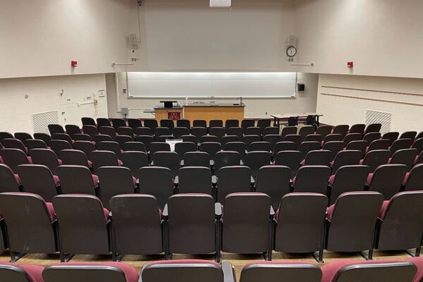 Front of room view with lectern on left and demonstration bench center in front of markerboard