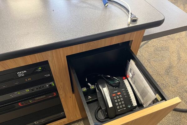 Pedestal - inside view of drawer showing two wireless mics in charging base and telephone