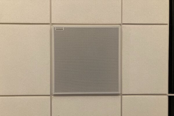 White 2¿ x 2¿ tile mounted in the ceiling to provide microphone coverage over student seating