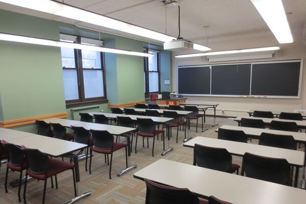 Front of room view with lectern on left side and projection screen partially lowered