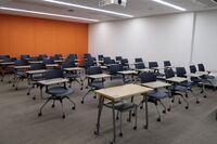 Rear of room view of student tablet arm chair seating on casters