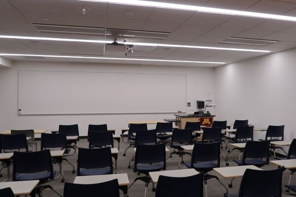 Front of room view with lectern on right side and projection screen fully raised