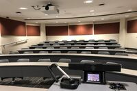 Back of room view of student tiered fixed table and chair seating 